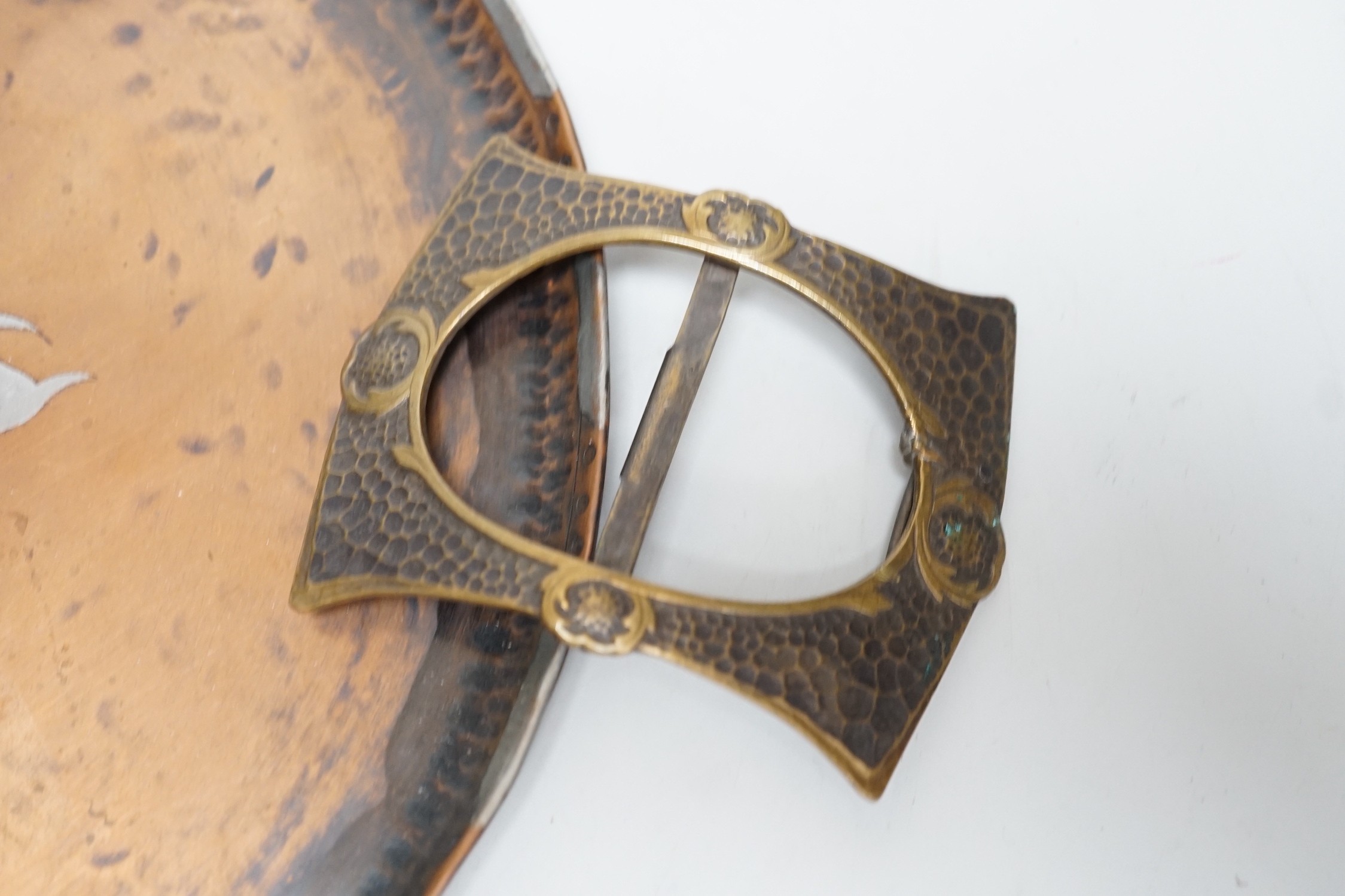 Paul Gillis. An Arts & Crafts copper tray and an Arts & Crafts buckle, tray 28cm diameter